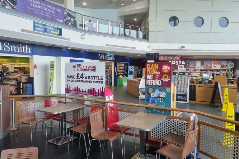 Empty tables at Burger King in the Dover ferry terminal, with Costa Coffee and WHSmith shops in the background.