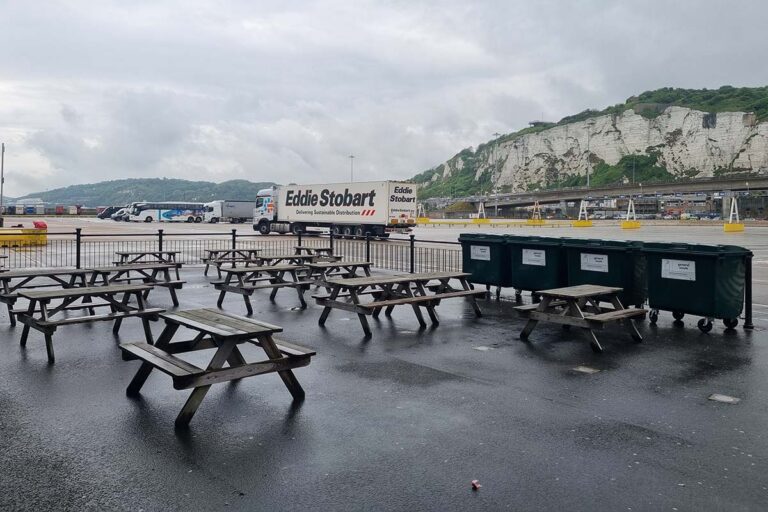 Empty picnic benches in the port area of Dover, overlooking the marshalling area and the white cliffs.